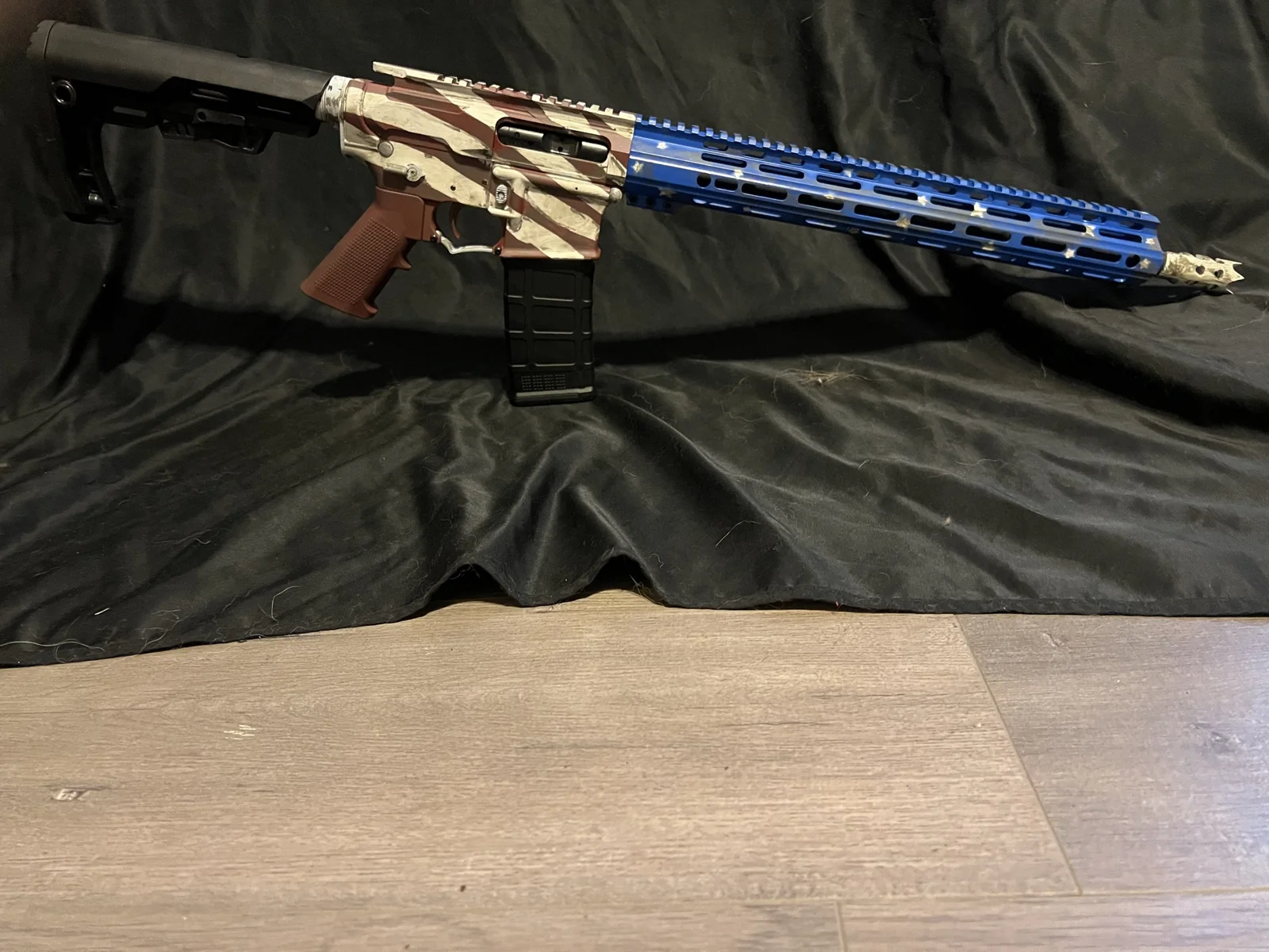 Battleworn American flag Cerakote AR-15 with stripes on the receivers and a star-pattern blue handguard by Tattoo Tactical