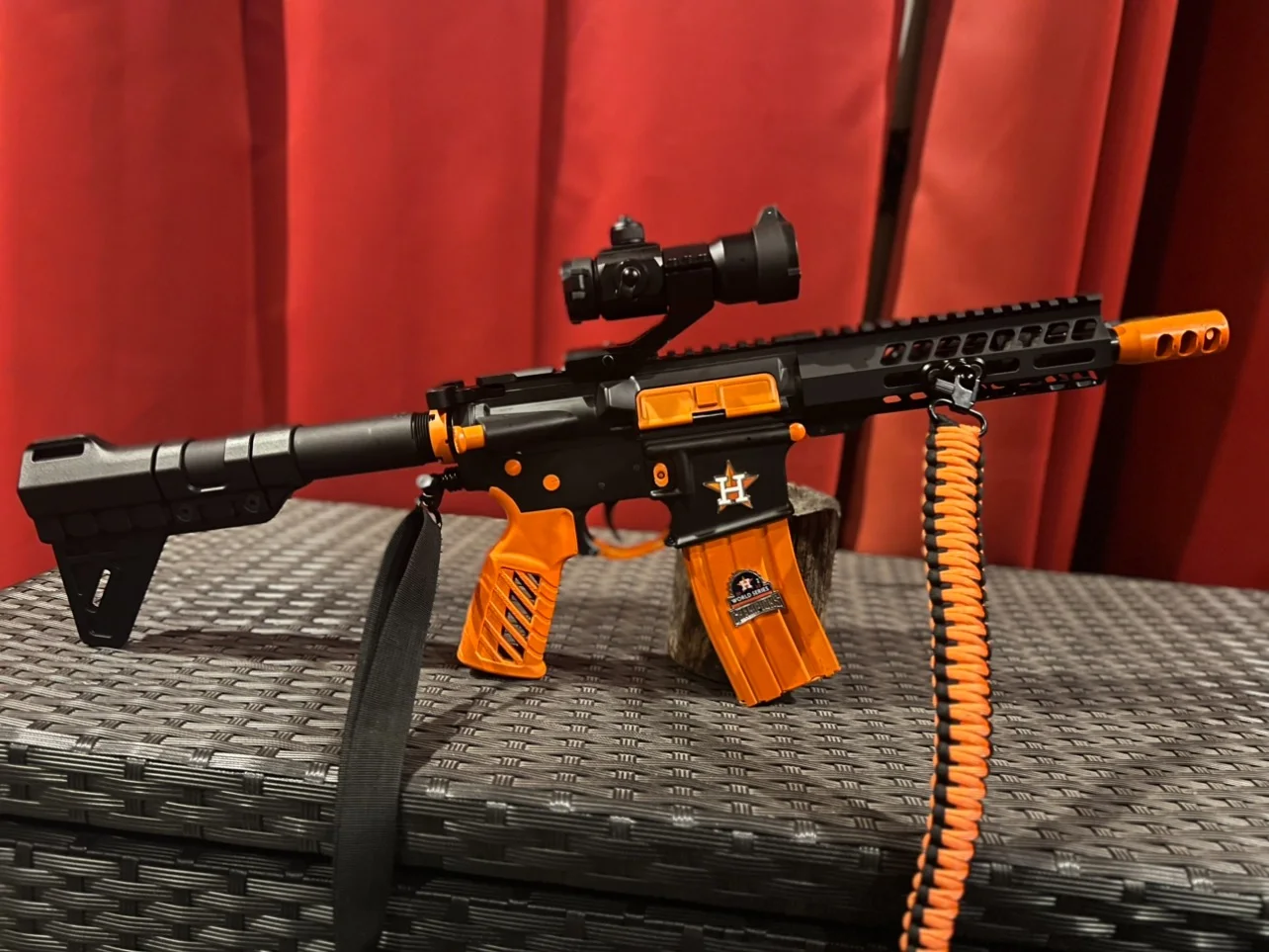 Astros themed custom Cerakote AR-15 with a 7.5-inch barrel in black with orange grip, magazine and accents by Tattoo Tactical