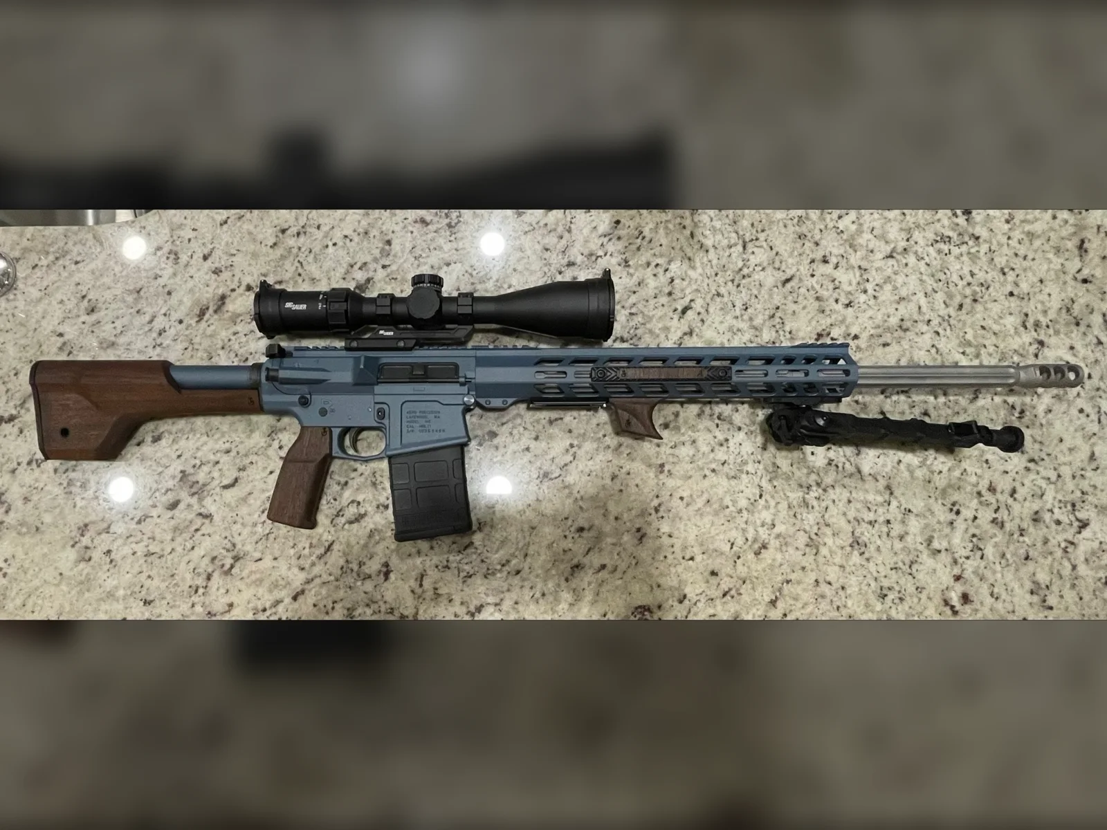 Precision rifle in a blue Cerakote finish with walnut stock, grip and handguard accents by Tattoo Tactical