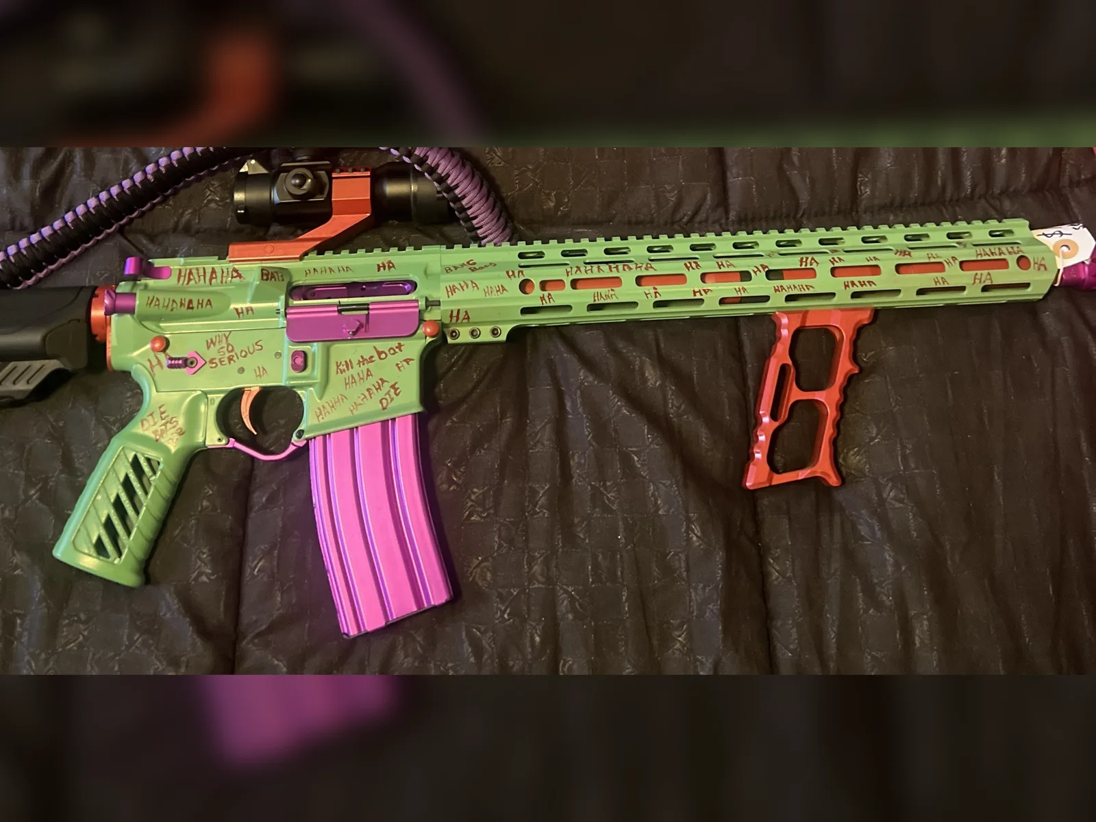 Green Joker themed Cerakote AR-15 with hand-lettered HAHA, purple magazine and orange accents by Tattoo Tactical