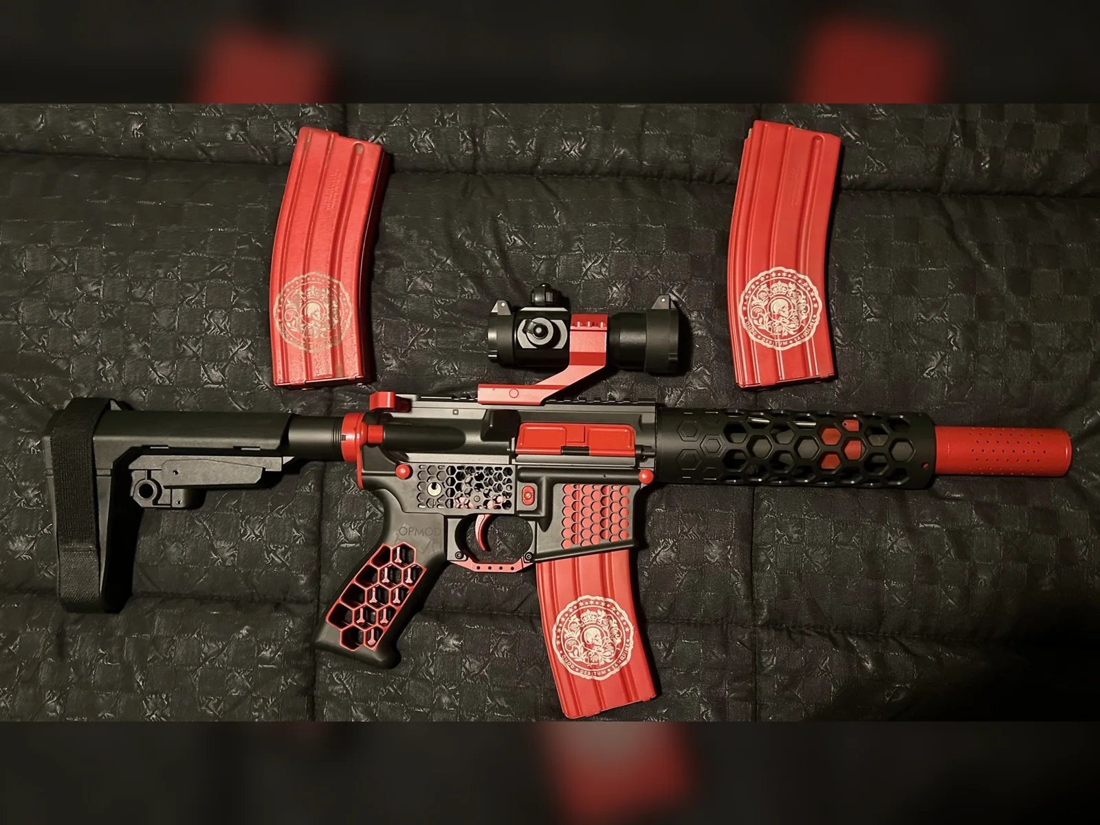 Black and red Cerakote AR-15 pistol with honeycomb parts and matching red magazines by Tattoo Tactical